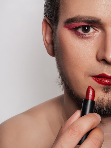 Nahaufnahme des hübschen bärtigen Mannes, der Make-up erhält