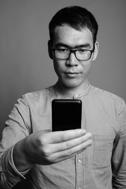 Nahaufnahme des jungen asiatischen Geschäftsmannes, der Brillen trägt