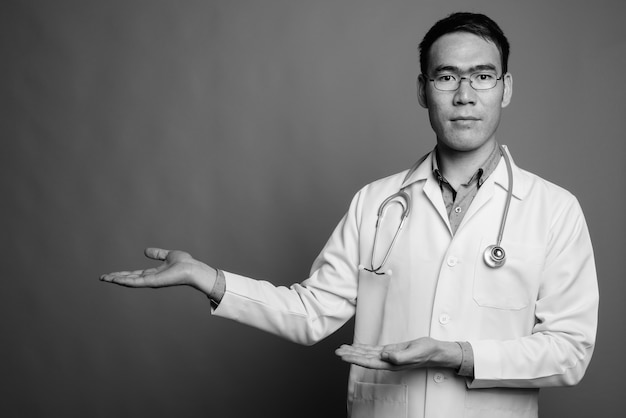 Nahaufnahme des jungen asiatischen Mannarztes, der Brillen trägt