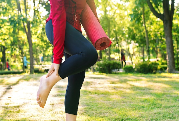 Nahaufnahme des jungen weiblichen Yoga im Park