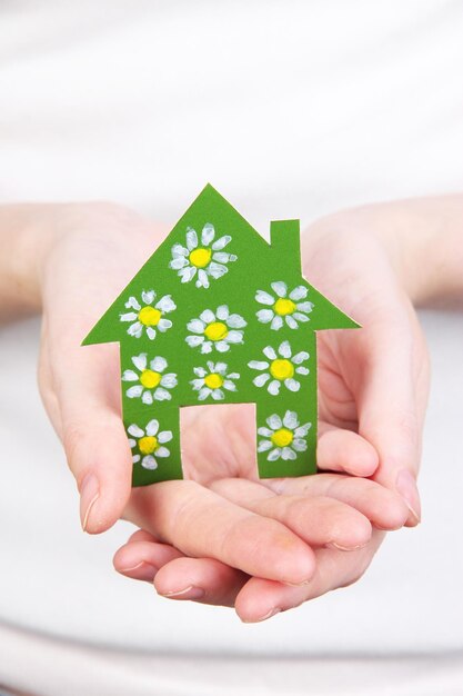 Nahaufnahme des kleinen Papierhauses in der Hand