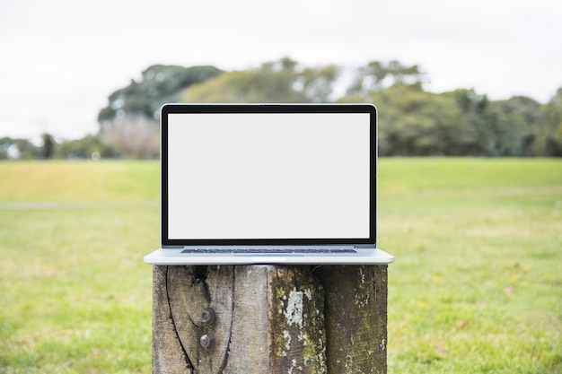 Foto nahaufnahme des laptops auf hölzernem beitrag im park