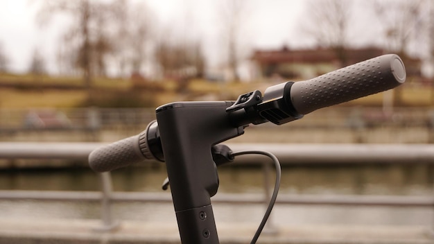 Nahaufnahme des Lenkrads eines Elektrorollers draußen. Der Beginn der Frühjahrssaison für das Rollerfahren.