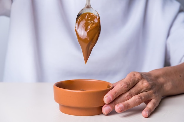 Nahaufnahme des Löffels, der die Dulce de Leche gießt