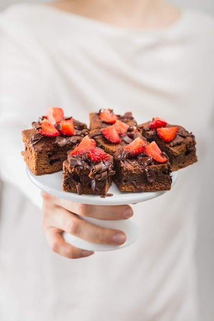 Nahaufnahme des Mädchens bereites Schokoladenschokoladenkuchen halten