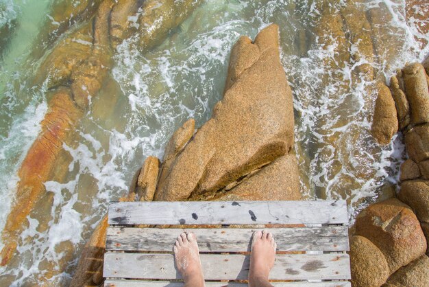 Nahaufnahme des männlichen Fußes im blauen Wasser am tropischen Strand. Ferien Urlaub.