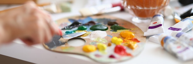 Nahaufnahme des Malers, der Ölfarben auf Palette mischt.