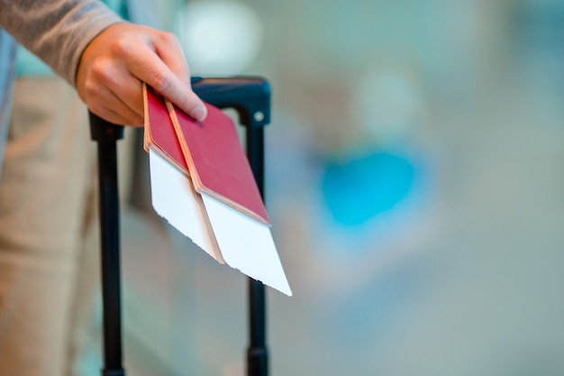 Nahaufnahme des Mannes Pässe und Bordkarte am Flughafen halten