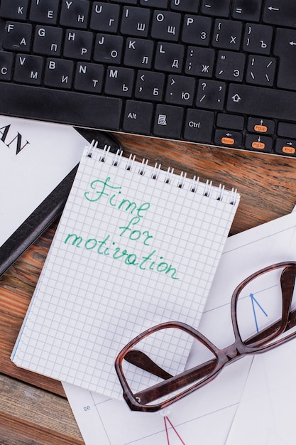 Nahaufnahme des Notizblocks mit Worten Zeit für Motivationsbrille und Tastatur am Arbeitsplatz