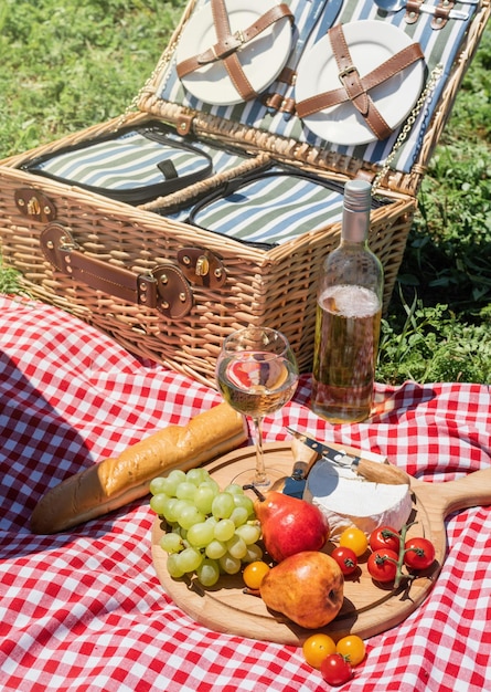 Nahaufnahme des Picknickkorbs mit Getränken und Speisen auf dem Rasen