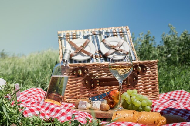 Nahaufnahme des Picknickkorbs mit Getränken und Speisen auf dem Rasen