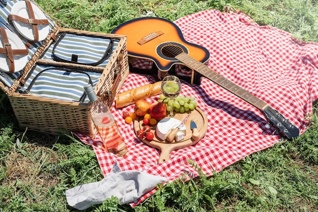 Nahaufnahme des Picknickkorbs mit Getränken und Speisen auf dem Rasen