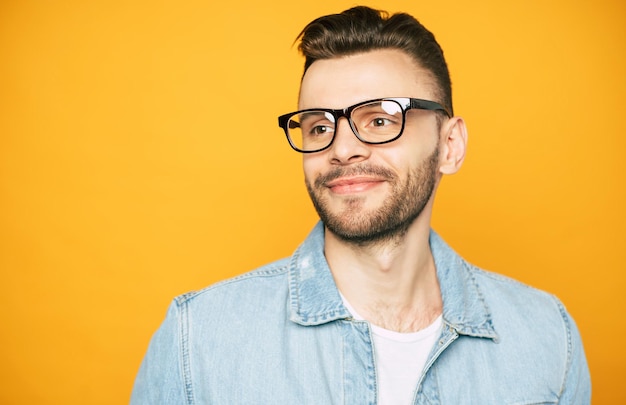 Nahaufnahme des Porträts eines gutaussehenden Bartmannes mit Brille isoliert auf gelbem Hintergrund