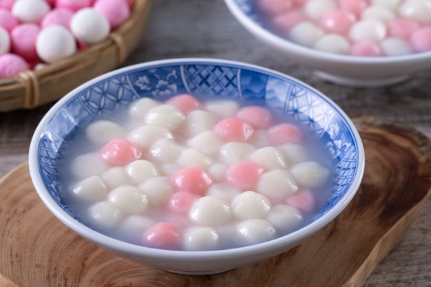 Nahaufnahme des roten und weißen Tangyuan (Tang Yuan, Klebreisknödelbällchen) in der blauen Schüssel. Wintersonnenwende Festival Essen.