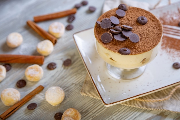 Nahaufnahme des schönen eleganten süßen Nachtischs, Tiramisu, serviert auf dem Teller. Teezeit, gemütliche Atmosphäre.