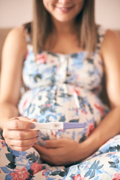 Nahaufnahme des Schwangerschaftstests in den Händen der jungen Frau