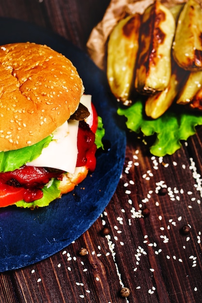 Nahaufnahme des selbst gemachten Rindfleischburgers mit dem Kopfsalat und Kartoffel diente