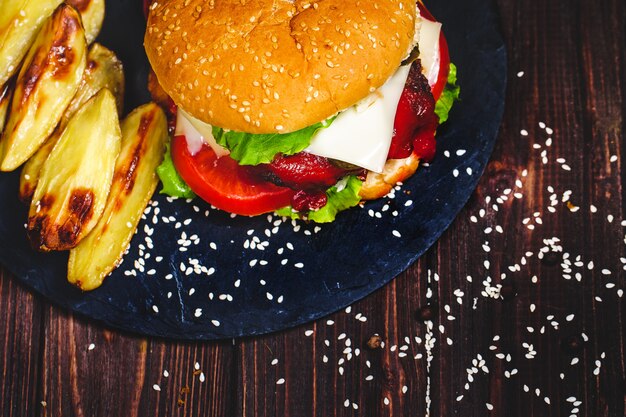 Nahaufnahme des selbst gemachten Rindfleischburgers mit dem Kopfsalat und Kartoffel diente