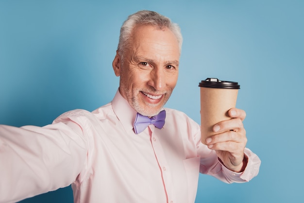 Nahaufnahme des Selbstporträts eines älteren Mannes, der Kaffee zum Mitnehmen trinkt
