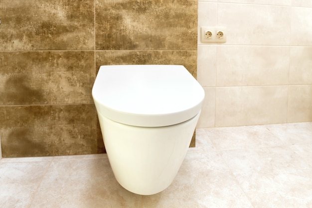 Nahaufnahme des Toilettenbadezimmers mit weißem Keramiksitz