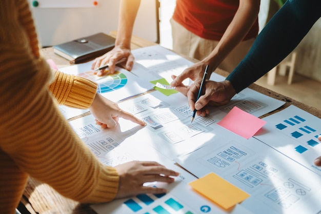 Nahaufnahme des UI-Entwicklerteams beim Brainstorming für ihr Projekt mit Laptop-Smartphone und digitalem Tablet
