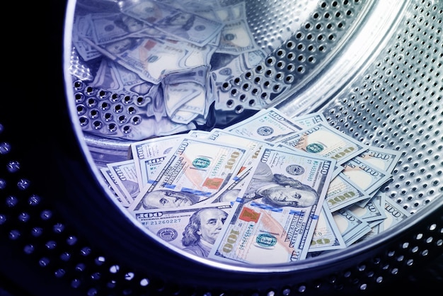Foto nahaufnahme des waschens von dollars im finanzbetrugskonzept der maschinengeldwäsche