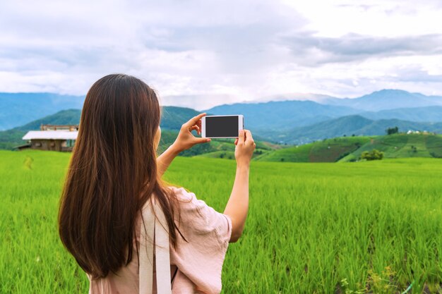 Nahaufnahme des weiblichen Reisenden unter Verwendung des Smartphones machen ein Foto an Reisfeldterrassen