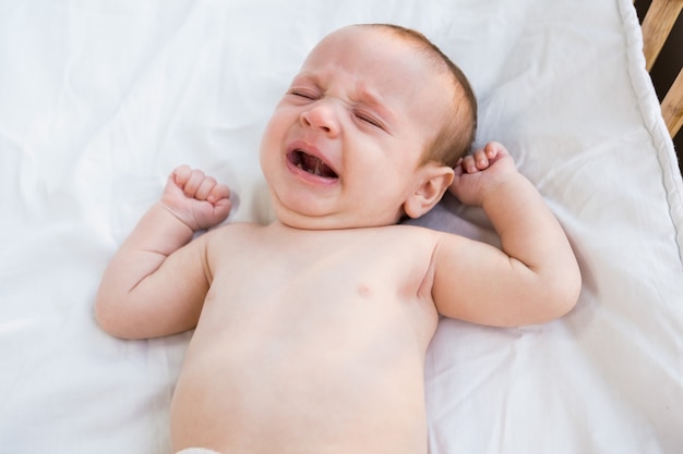 Nahaufnahme des weinenden Babys auf Babybett