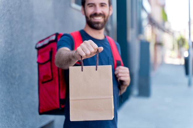 Nahaufnahme des Zustellers, der Paketkasten liefert. Kurierdienstkonzept. horizontale ansicht eines nicht erkennbaren fahrers, der ein paket nach hause liefert.