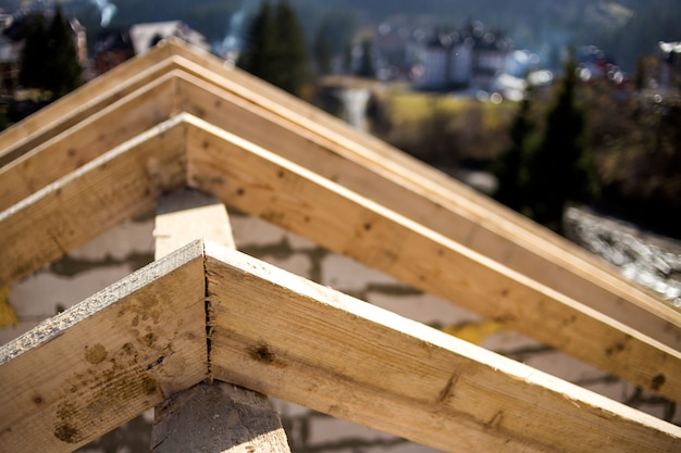 Nahaufnahme Detail des Dachrahmens der rauen Holzbalken auf Hintergrund der nebligen Berglandschaft im ökologischen Bereich. Bau-, Dach-, Bau- und Renovierungskonzept.