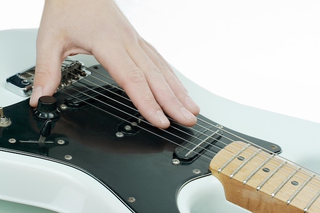 Nahaufnahme.die Hand des Musikers, der die Saiten einer Gitarre streicht.auf einem weißen Hintergrund isoliert