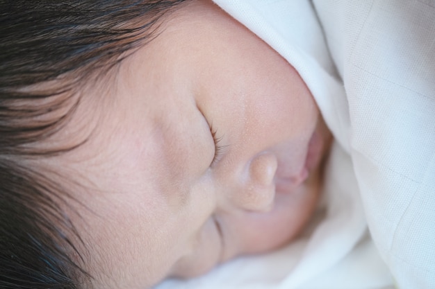 Nahaufnahme ein Baby, das bequem auf dem Bett schläft