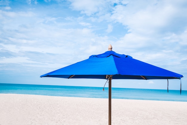 Nahaufnahme: ein blauer Regenschirm am Strand. Seehorizont und bewölkter Himmel auf dem Hintergrund.