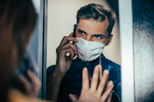 Nahaufnahme. ein junger mann und eine frau schauen sich ängstlich durch das glas an. Foto mit Textfreiraum