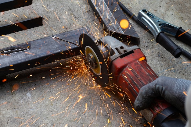 Nahaufnahme, Ein Mann, der mit Winkelschleifer arbeitet. Reparatur des Eisernen Tors