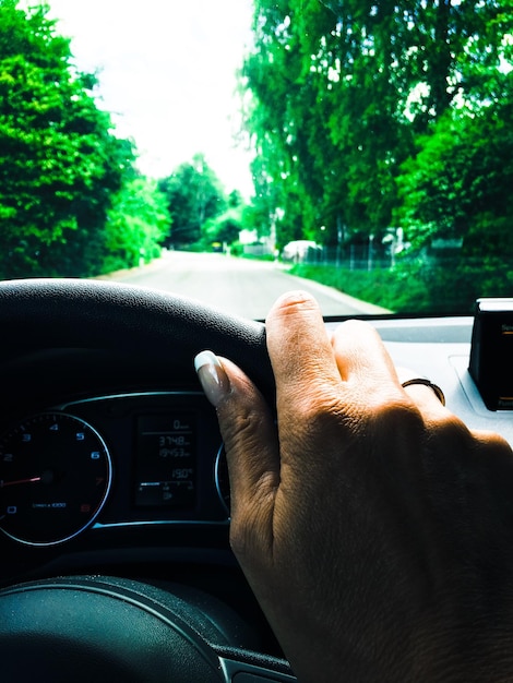 Foto nahaufnahme einer abgeschnittenen hand, die ein auto auf der straße fährt