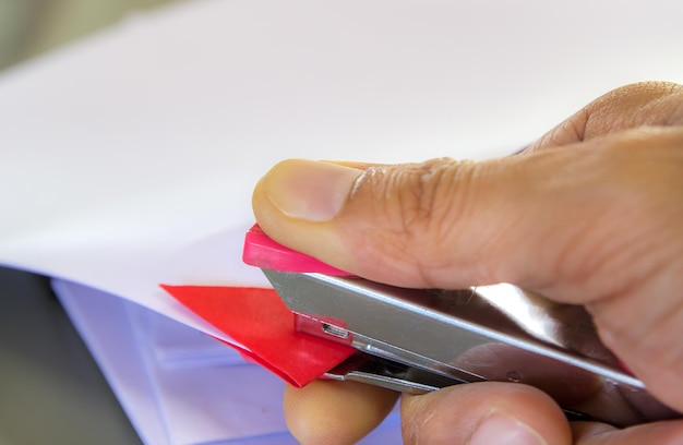 Nahaufnahme einer abgeschnittenen Hand mit einer Heftmaschine