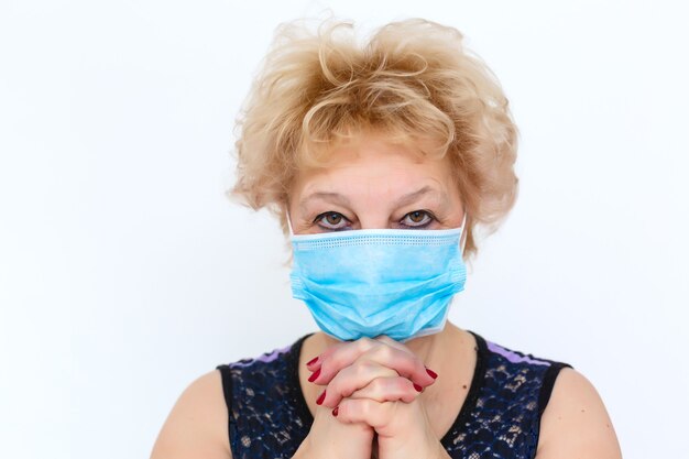 Nahaufnahme einer älteren Frau mit einer medizinischen Maske im Gesicht. Das globale Problem des Coronavirus.