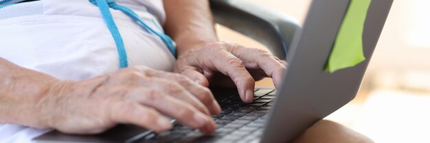 Nahaufnahme einer alten Frau, die auf modernen Laptops arbeitet oder nach Informationen sucht, ältere Frauen tippen auf