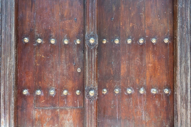 Nahaufnahme einer alten traditionellen geschnitzten Holztür mit Ornamenten und Bronzespitze in Stone Town auf der Insel Sansibar Tansania Ostafrika