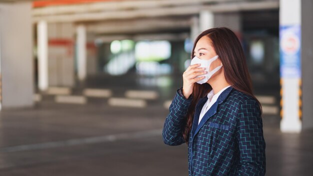 Nahaufnahme einer asiatischen Frau, die eine schützende Gesichtsmaske für das Gesundheitswesen und das Viruskonzept Covid-19 oder 2020 trägt