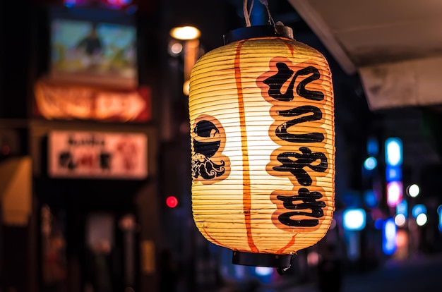 Nahaufnahme einer beleuchteten japanischen Laterne, die nachts im Freien hängt