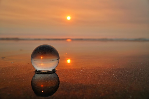 Foto nahaufnahme einer beleuchteten kerze am strand bei sonnenuntergang