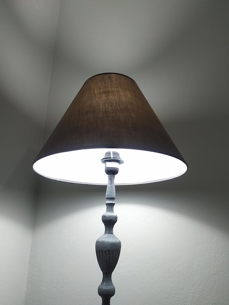 Nahaufnahme einer beleuchteten Lampe an der Wand zu Hause