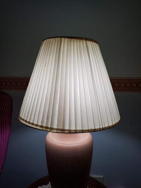 Nahaufnahme einer beleuchteten Lampe an der Wand zu Hause