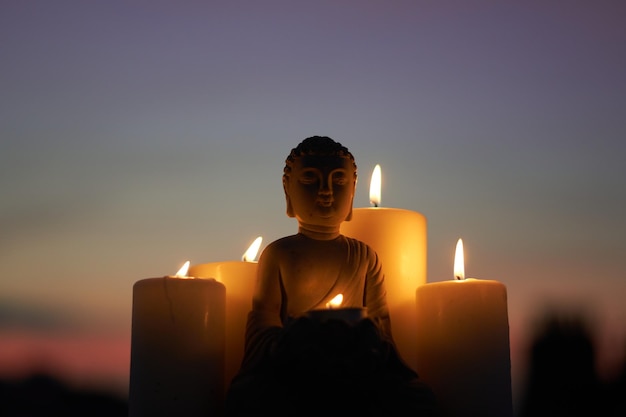 Foto nahaufnahme einer buddha-figur mit beleuchteten kerzen