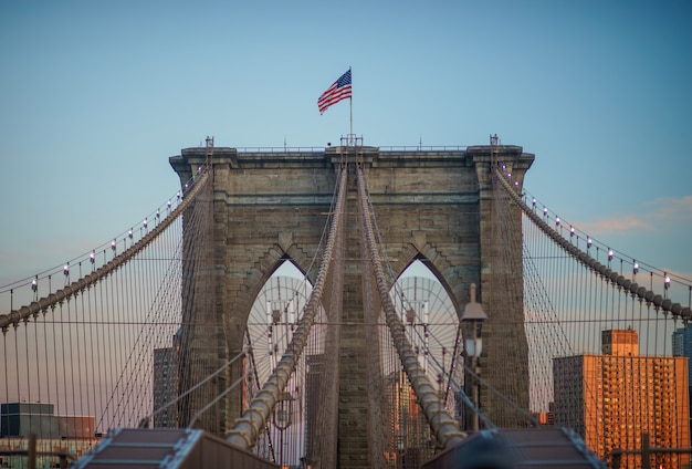 Nahaufnahme einer der Turmstrukturen der Brooklyn-Brücke, die das Sternenbanner auf der Oberseite fliegt