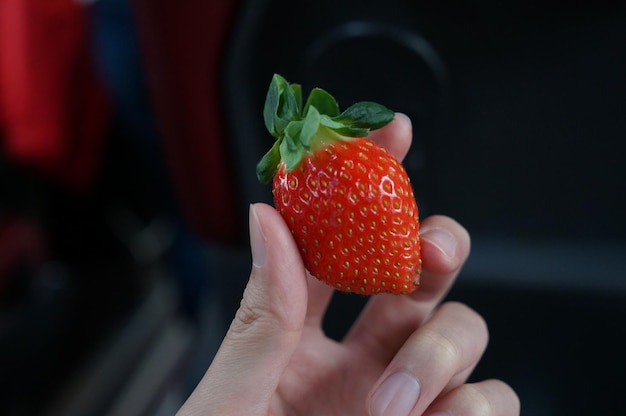 Foto nahaufnahme einer erdbeere in der hand