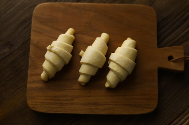 Nahaufnahme einer flauschigen, ungekochten, rohen, traditionellen französischen Croissants-Teigrolle.