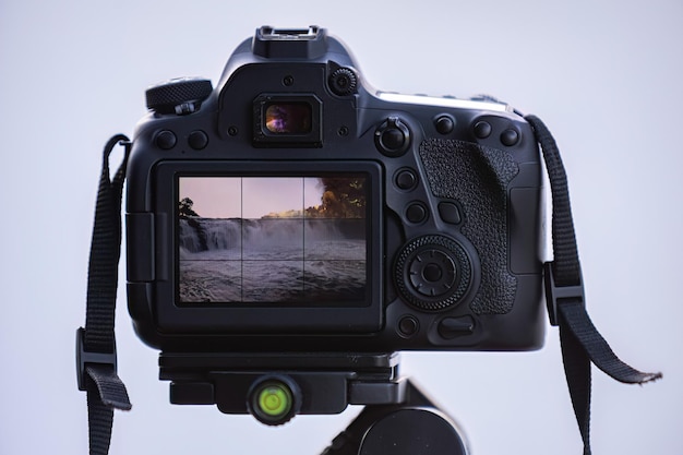 Nahaufnahme einer Fotokamera auf einem Stativ, um einen Wasserfall mit selektivem Fokus zu fotografieren